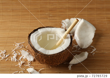 Tasty coconut with straw on bamboo background 72765729