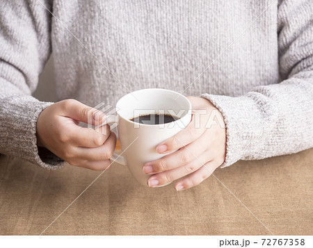 コーヒーカップを持つ女性の手の写真素材