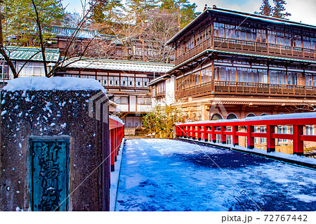 アニメ千と千尋の神隠しのモデルと言われている四万温泉旅館積善館の赤い橋に雪が積もった冬の思い出の写真素材