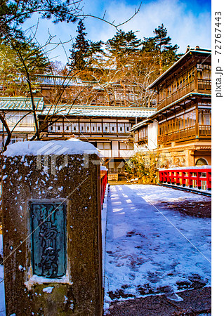 アニメ千と千尋の神隠しのモデルと言われている四万温泉旅館積善館の赤い橋に雪が積もった冬の思い出の写真素材