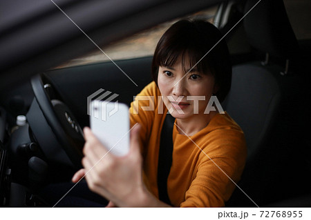 慌ててスマートフォンで撮影する女性 慌ててスマートフォンで撮影する女性 72768955