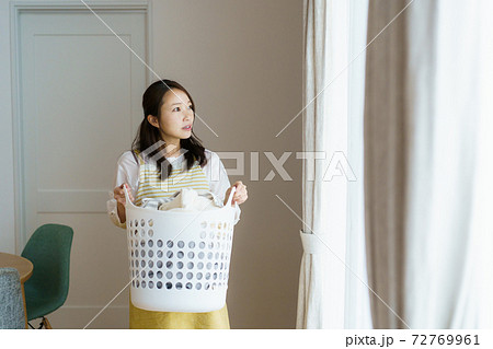 洗濯物を持っている女性 72769961