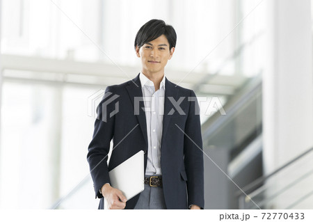 ノートパソコンを持った30代前半のビジネスマン 72770433