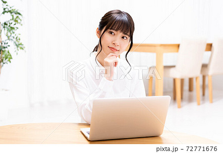 リビングでノートパソコンを使う女性 リビングでノートパソコンを使う女性 72771676