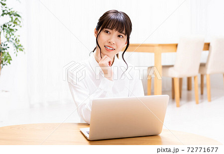 リビングでノートパソコンを使う女性 リビングでノートパソコンを使う女性 72771677