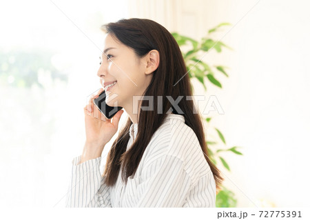 スマホで通話する若い女性 72775391
