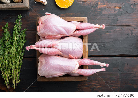 Whole quails with spices, herbs, vegetables, top view, on dark wooden background with copy space Whole quails with spices, herbs, vegetables, top view, on dark wooden background with copy space 72777090