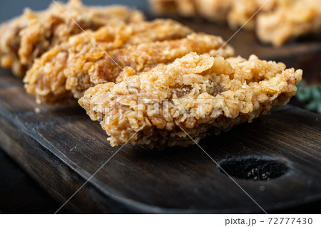 Breaded chicken wings on dark wooden background, with space for text 72777430