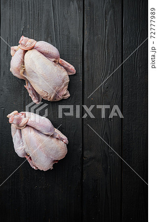 Organic whole poussins, on black wooden table, top view with copy space for text 72777989