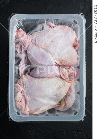 Plastic container with raw chicken, on black background, top view 72778011
