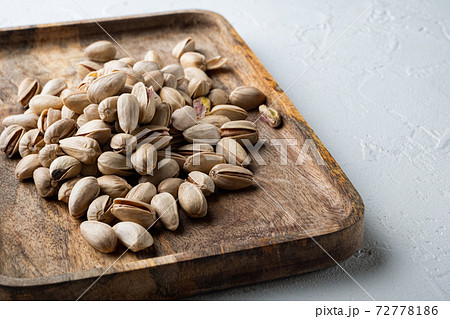 Shelled unsalted pistachios, on white textured background 72778186