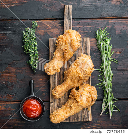 Breaded kentucky chicken drumctick on dark wooden background, flat lay Breaded kentucky chicken drumctick on dark wooden background, flat lay 72778456