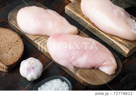 Raw crumbet chicken fillet with ingredients on dark wooden background Raw crumbet chicken fillet with ingredients on dark wooden background 72778622