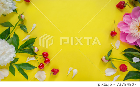 Flowers of peony, branches, leaves and petals and berries of cherry, strawberry with space for text on a yellow background. Flat lay, top view. Flowers of peony, branches, leaves and petals and berries of cherry, strawberry with space for text on a yellow background. Flat lay, top view. 72784807