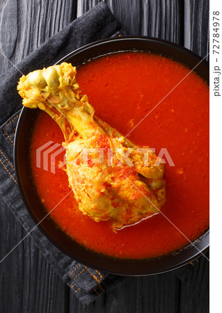 Traditional Guatemalan kakik soup features dark turkey meat in a delicious, lightly-spiced red broth closeup on the table. Vertical top view Traditional Guatemalan kakik soup features dark turkey meat in a delicious, lightly-spiced red broth closeup on the table. Vertical top view 72784978