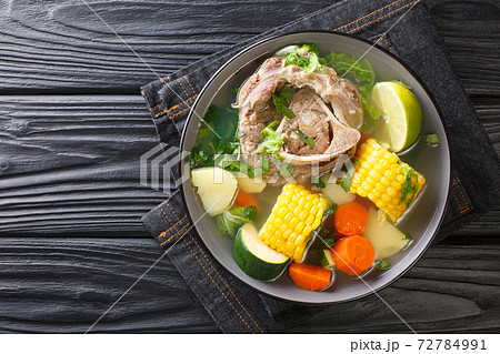 Delicious Caldo de res Mexican beef shank soup with vegetables close-up in a bowl on the table. horizontal top view Delicious Caldo de res Mexican beef shank soup with vegetables close-up in a bowl on the table. horizontal top view 72784991