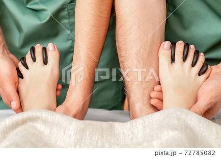Massage stones between the toes. Massage stones between the toes. 72785082