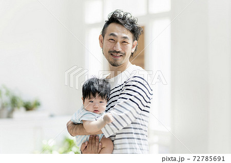 赤ちゃんを抱っこする父親 赤ちゃんを抱っこする父親 72785691