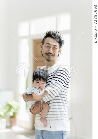赤ちゃんを抱っこする父親の写真素材