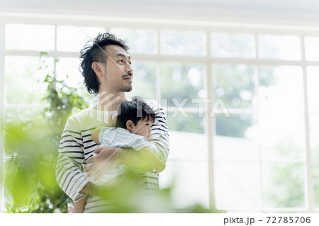 赤ちゃんを抱っこする父親の写真素材