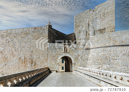 Croatia. South Dalmatia. Defensive wall of the old city of Dubrovnik, entrance via a bridge over an arch. 72787910