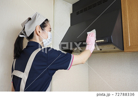 ガスレンジの換気扇の掃除をするハウスクリーニングの女性作業員の写真素材 7276