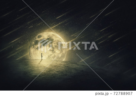 Surreal world scene with a person silhouette, alone on a dry empty land, looking at the starry night sky with comets falling, over a full moon background. Spatial phenomenon, conceptual landscape. 72788907