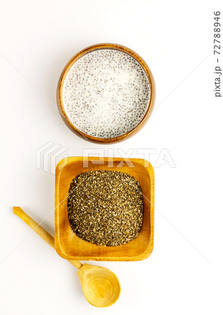 Chia seed milk pudding and dry seeds in bamboo bowls with wooden rustic spoon. Top view. Flat lay 72788946