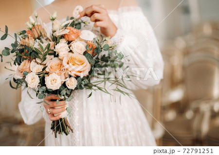 wedding bouquet with peonies in the hands of the bride under the veil.Morning of the bride 72791251