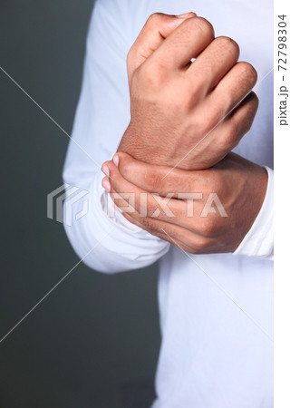 Young man in suffering wrist pain, close up Young man in suffering wrist pain, close up 72798304