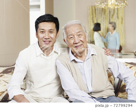 portrait of senior father and adult son sitting on couch at home portrait of senior father and adult son sitting on couch at home 72799294