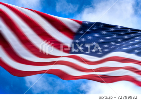 American flag blowing in wind against sky American flag blowing in wind against sky 72799932