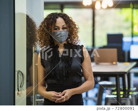 Portrait of woman in face mask standing in office Portrait of woman in face mask standing in office 72800091