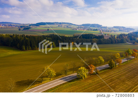 Aerial view of the autumn forest and road between the hills. Czech Republic 72800803