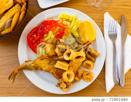 Fried squid rings and fish with vegetables and lemon Fried squid rings and fish with vegetables and lemon 72801980