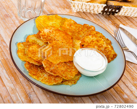 Draniki with sour cream at plate, dish of Belarusian cuisine 72802490