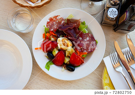 Catalan salad with fresh vegetables, egg and slices of sausages Catalan salad with fresh vegetables, egg and slices of sausages 72802750