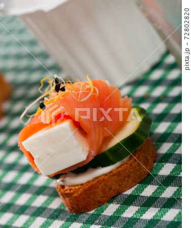 Canape with salmon, young cheese, cucumber 72802820