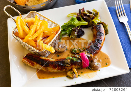 Pork sausages with mushrooms, french fries and lettuce Pork sausages with mushrooms, french fries and lettuce 72803264