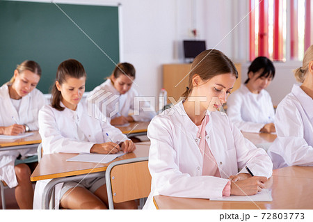 Medical students writing in notepads Medical students writing in notepads 72803773