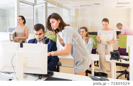 Ordinary girl helping male colleague in work 72805029