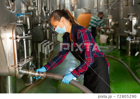 Female worker in mask working at winery Female worker in mask working at winery 72805290