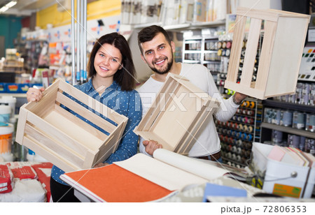 loving couple demonstrating boxes for decorating house in paint store 72806353