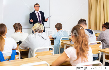 Male teacher conducting lesson for teenage schoolchildren Male teacher conducting lesson for teenage schoolchildren 72806501