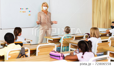 Female teacher in mask lecturing to children Female teacher in mask lecturing to children 72806558