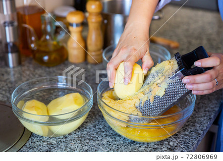 Shredding potato using grater for vegetable pancakes 72806969