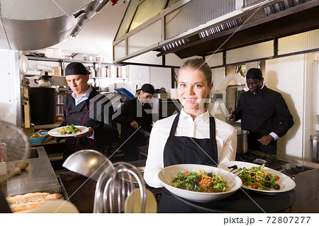 Waitress in restaurant kitchen with ordered meals 72807277