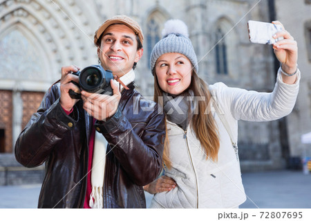 Couple man and woman in the historic center with camera and phone Couple man and woman in the historic center with camera and phone 72807695