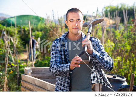 Positive man professional horticulturist with garden shovel at land Positive man professional horticulturist with garden shovel at land 72808278