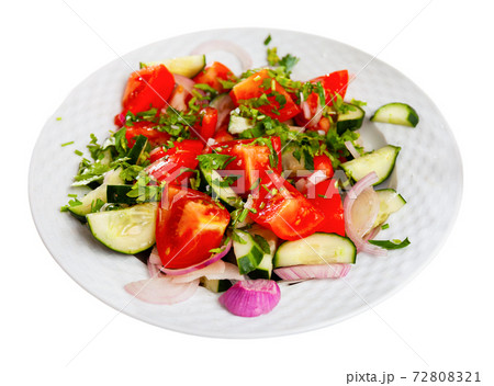 Delicious summer salad of cucumbers and tomatoes on plate 72808321